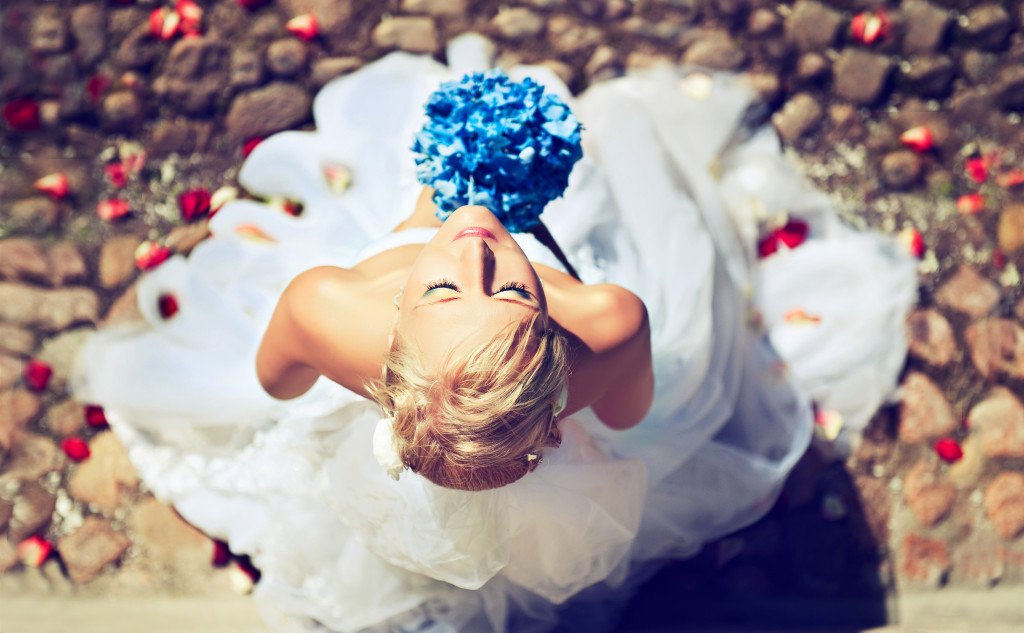 Beautiful blonde bride in bridal makeup with a bouquet of flowers